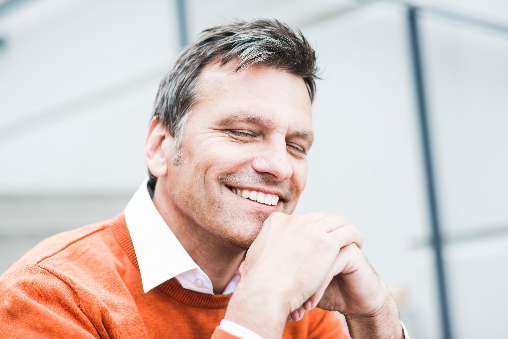 Businessman wearing orange sweater, portrait